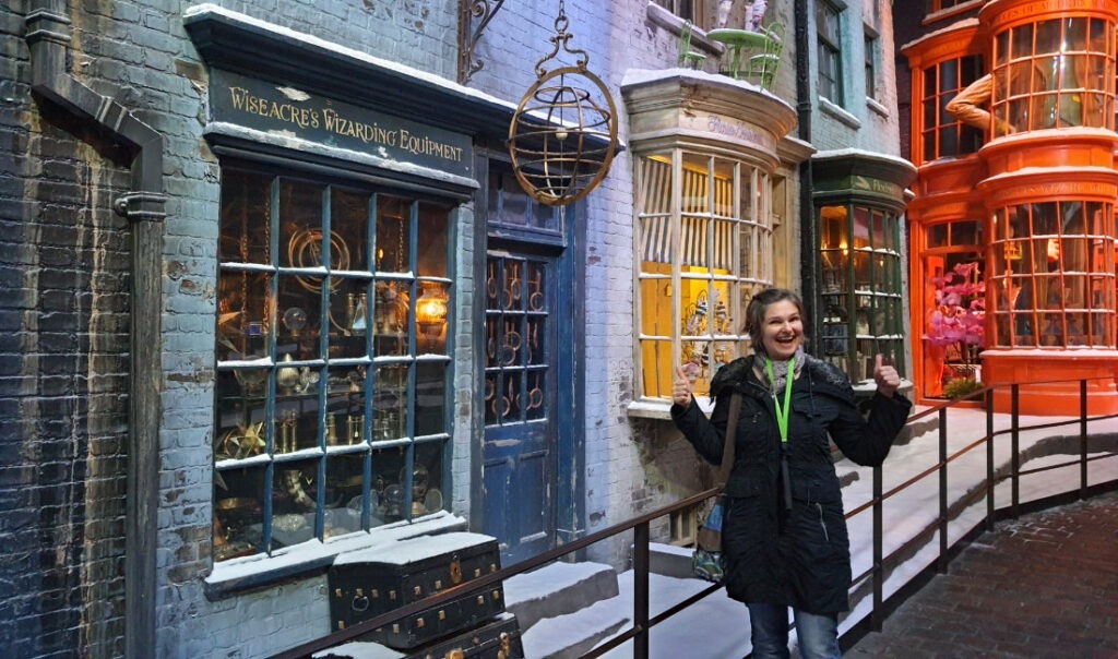 Nachbau der Winkelgasse aus den Harry Potter-Filmen, im Vordergrund Susa lachend mit angewinkelten, erhobenen Armen